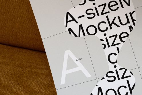 Paper mockups scattered on brown fabric showcasing various font sizes ideal for graphic design presentations or font display.