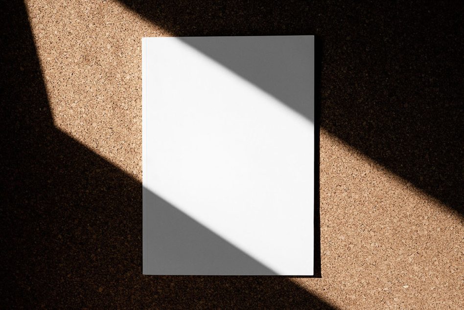 Blank white card mockup with natural sunlight casting diagonal shadow