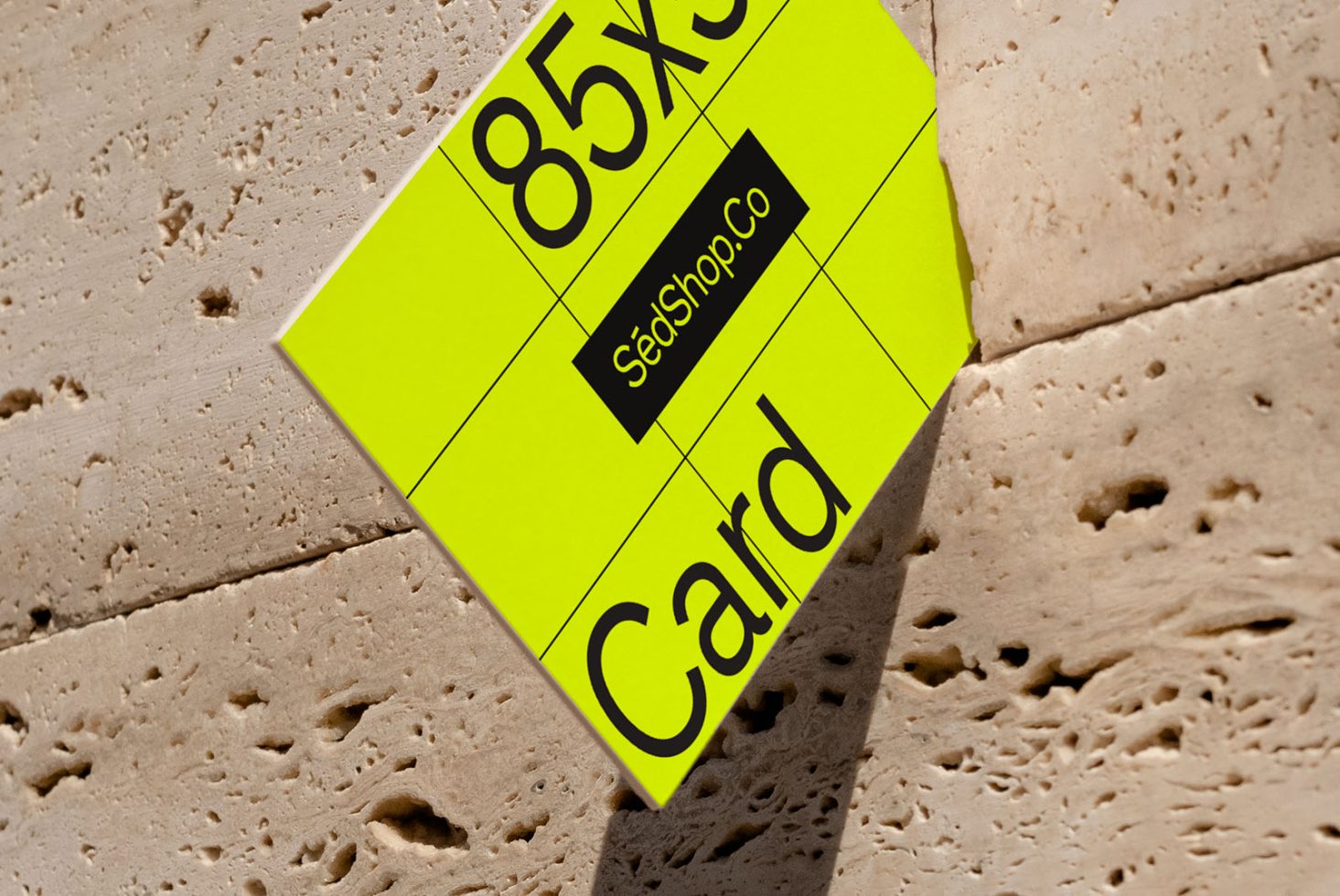 ALT: Business card mockup with yellow design on textured surface, presenting 85x55 mm dimensions for graphic designers.