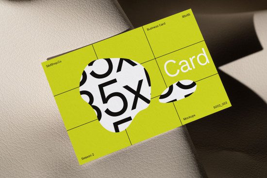 Business card mockup on textured background, modern design, eye-catching yellow with bold black typography and patterns, ideal for designers.