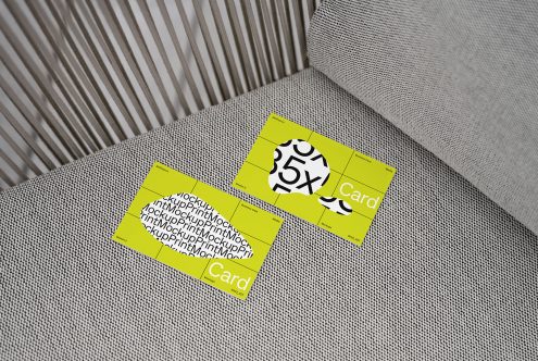 Business card mockup on textured couch with bright yellow design and bold typography, ideal for realistic presentation and portfolio display.