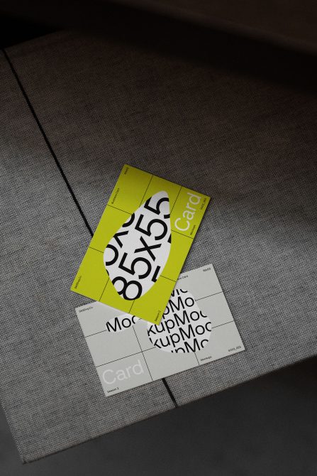 Bright lime card mockup with bold typography overlapping white business cards on dark textile backdrop