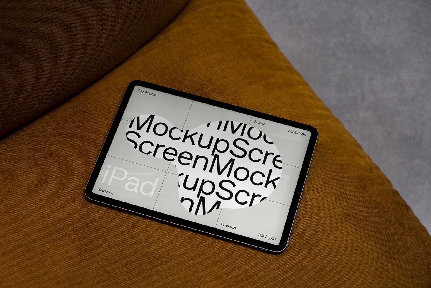 iPad digital mockup on brown couch cushion showcasing designer screen layout, ideal for presentations and digital portfolio displays.