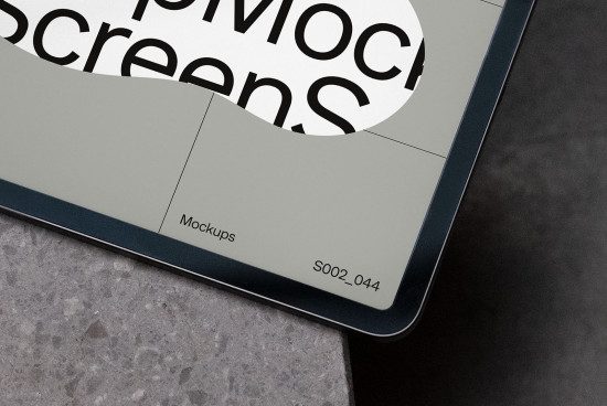 Close-up view of a digital tablet mockup on a textured surface, showcasing a design interface for creative professionals.