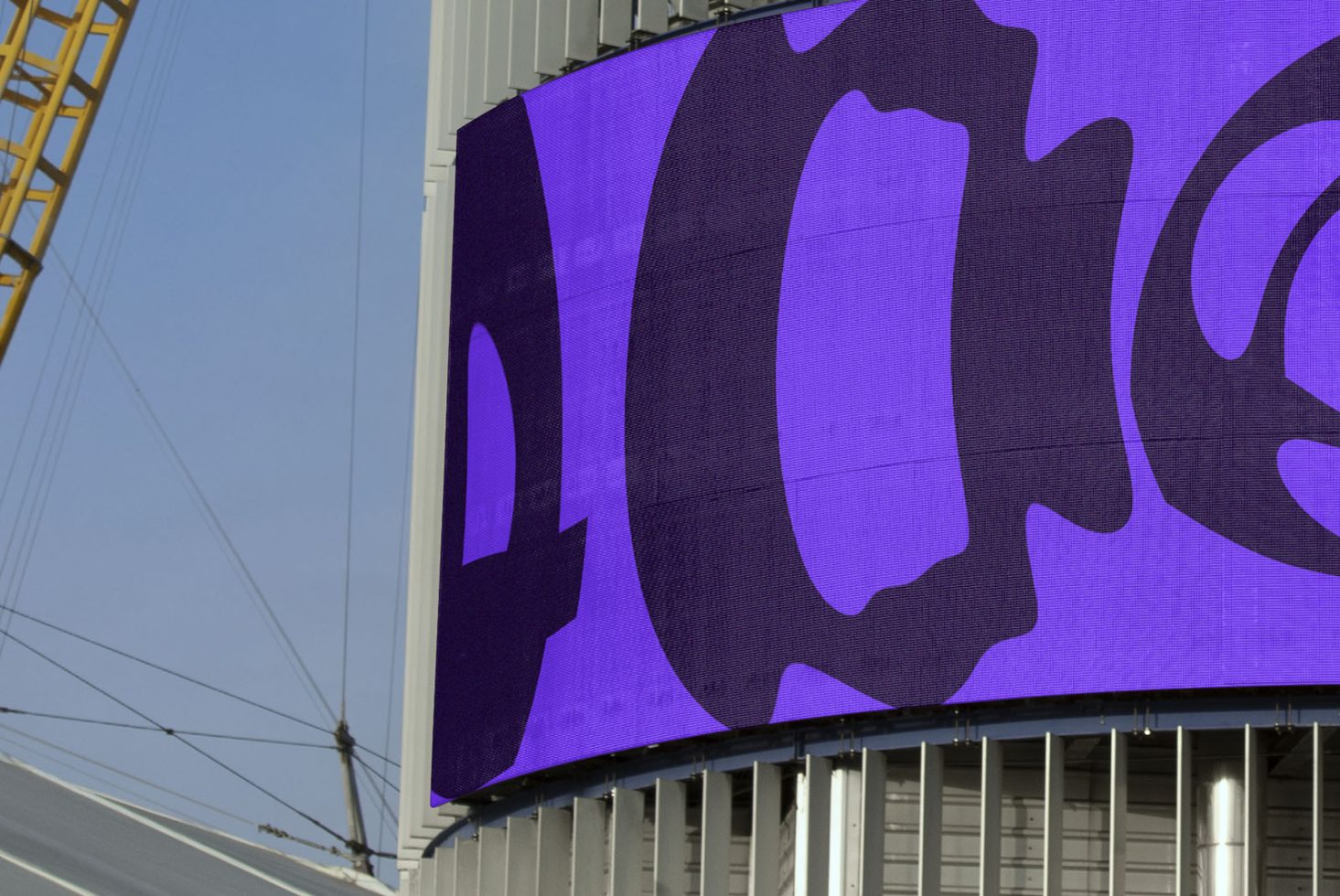 Billboard mockup on urban building showcasing large vibrant digital advertisement, clear sky background, design presentation tool.