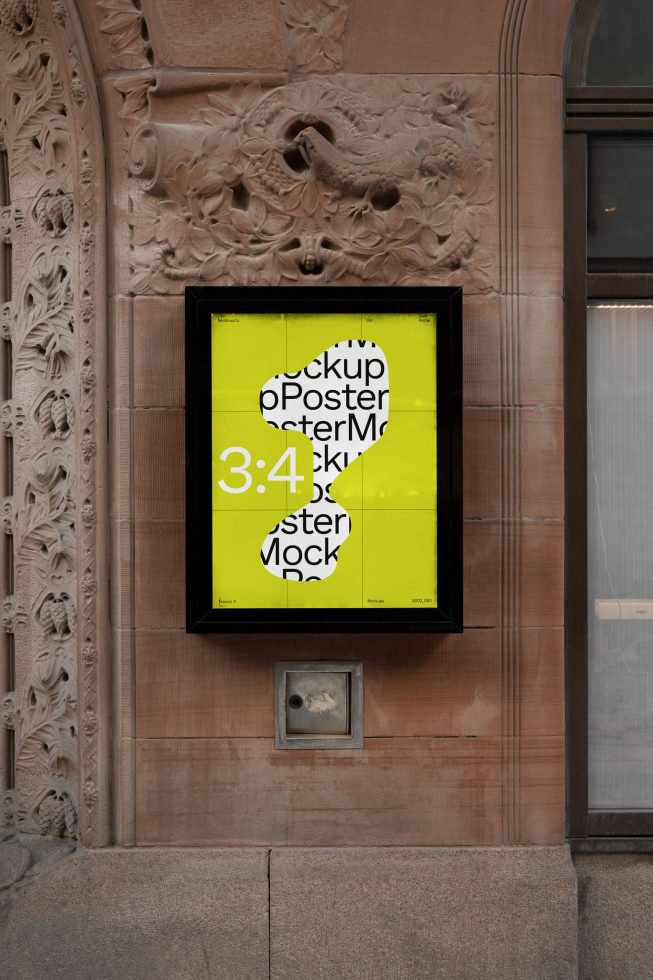 Outdoor poster mockup in a black frame on a decorative stone wall displaying vibrant yellow design, suitable for designers' presentation.