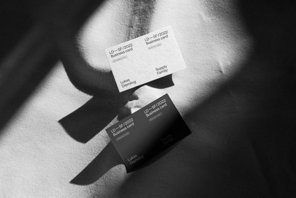 White black business cards arranged on linen with sharp shadow details
