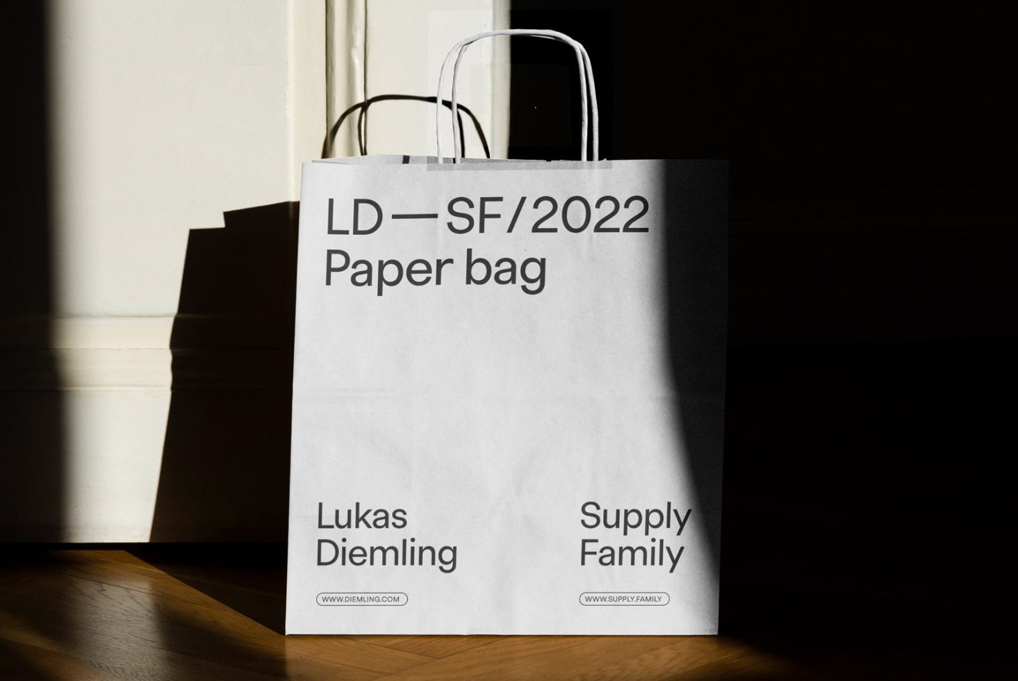 Elegant paper bag mockup design with typography in sunlight and shadow for branding presentation, ideal for graphics display on digital asset marketplaces.