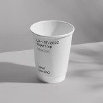 Minimalist paper cup mockup in black and white with subtle shadows, perfect for showcasing logo and branding designs.