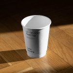 Photorealistic paper cup mockup on wooden surface with natural shadows, suitable for branding and packaging design presentations.