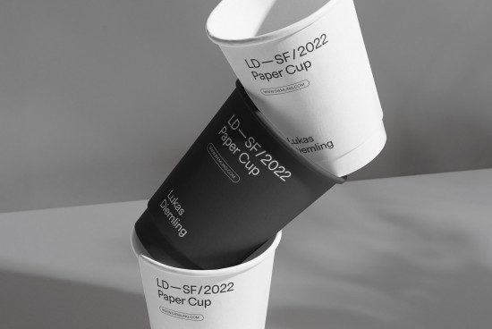 Black and white paper cup mockup design with minimalist branding, suitable for showcasing packaging and branding designs.