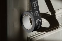 Black duct tape roll with white text showing branding mockup