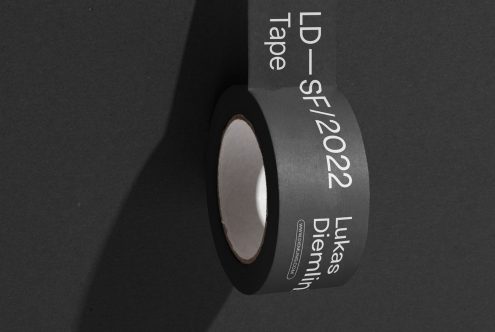 Black adhesive tape roll with white typographic design on dark background, ideal for mockup material, graphic design, and creative presentation.