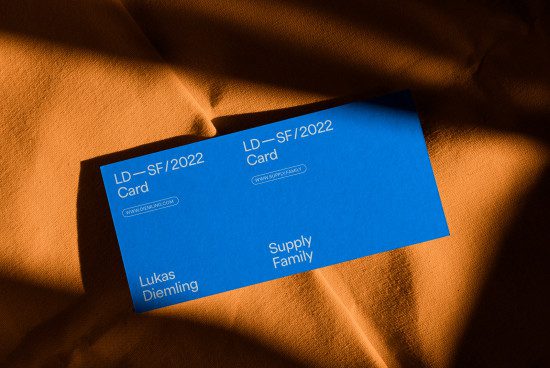 Blue business card mockup on textured fabric with dynamic shadows for designers' presentations, branding, and identity projects.