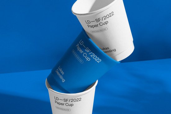 Blue and white paper cup mockup design on a contrasting blue background, ideal for branding presentations and graphic design.