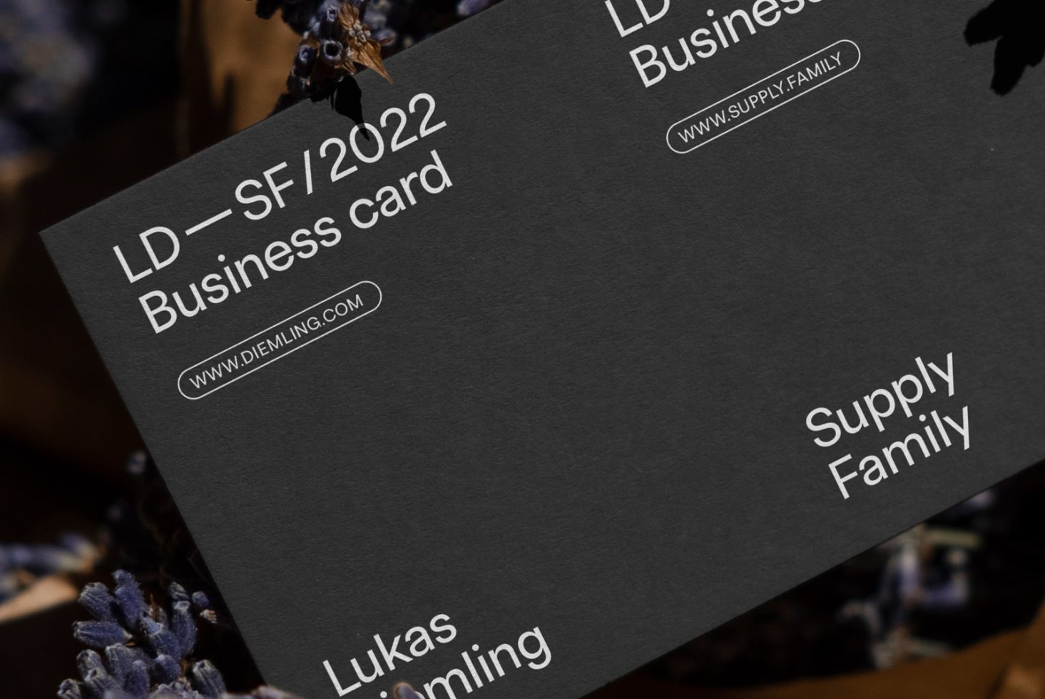 Elegant black business card mockup with white typography, ideal for designers to showcase branding identity designs.