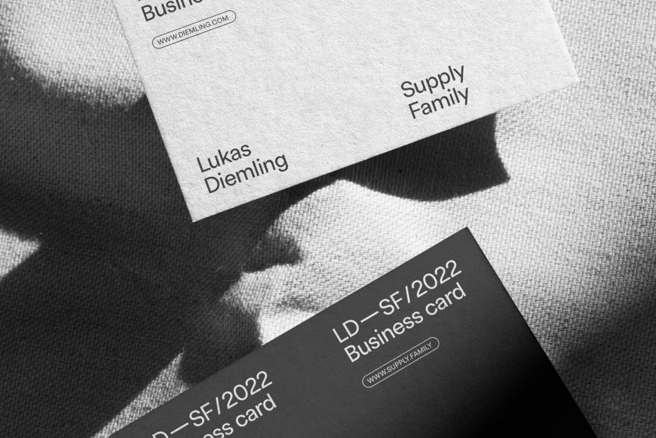 Overlapping business cards on beige textile surface in monochrome style