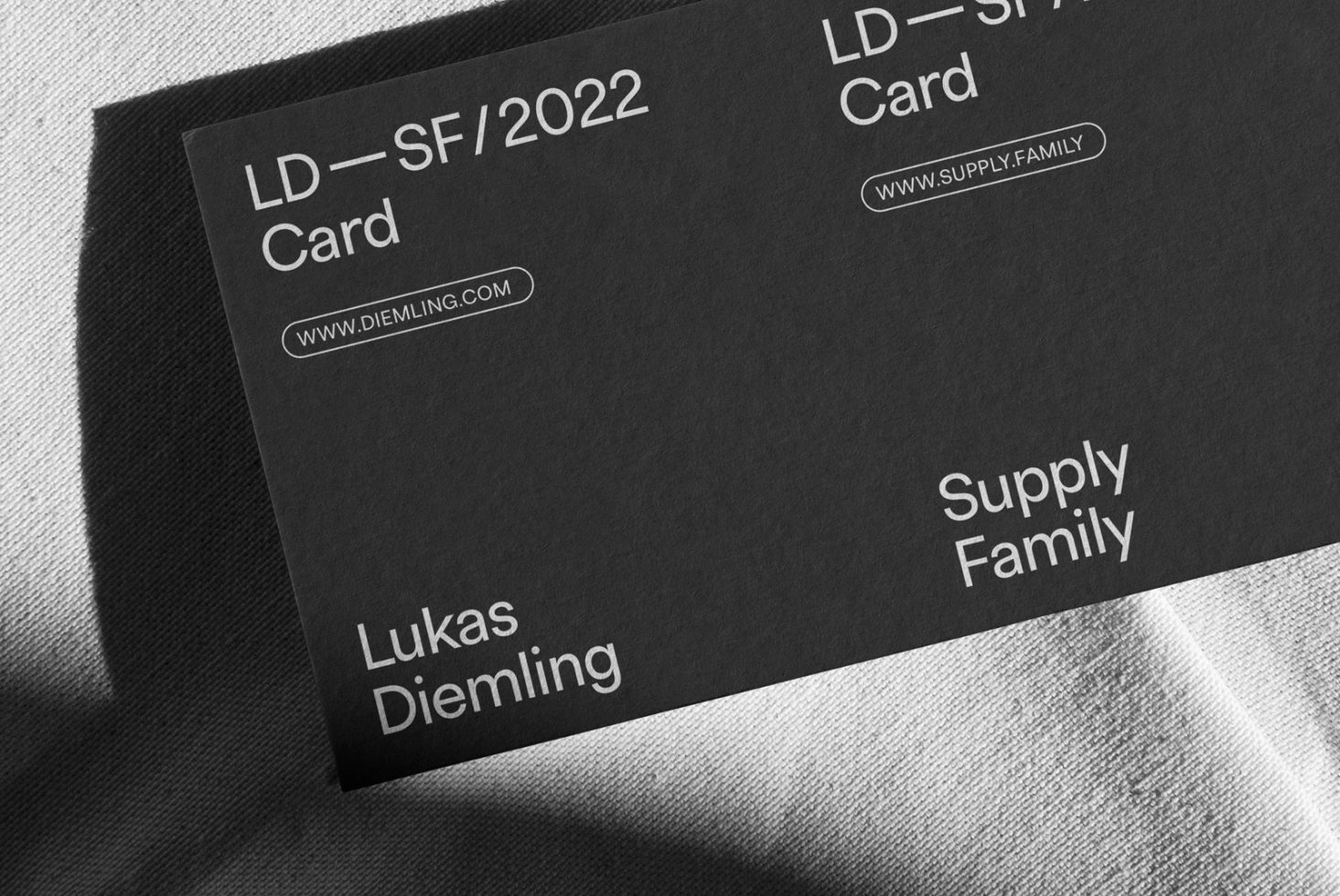 Elegant black business card mockup on fabric texture, showcasing clean design and typography for corporate identity and branding.