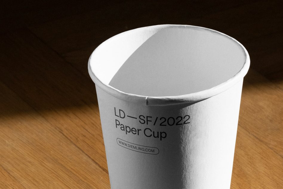 Close-up of a paper cup mockup on a wooden surface, with space for design branding, perfect for packaging mockup design assets.