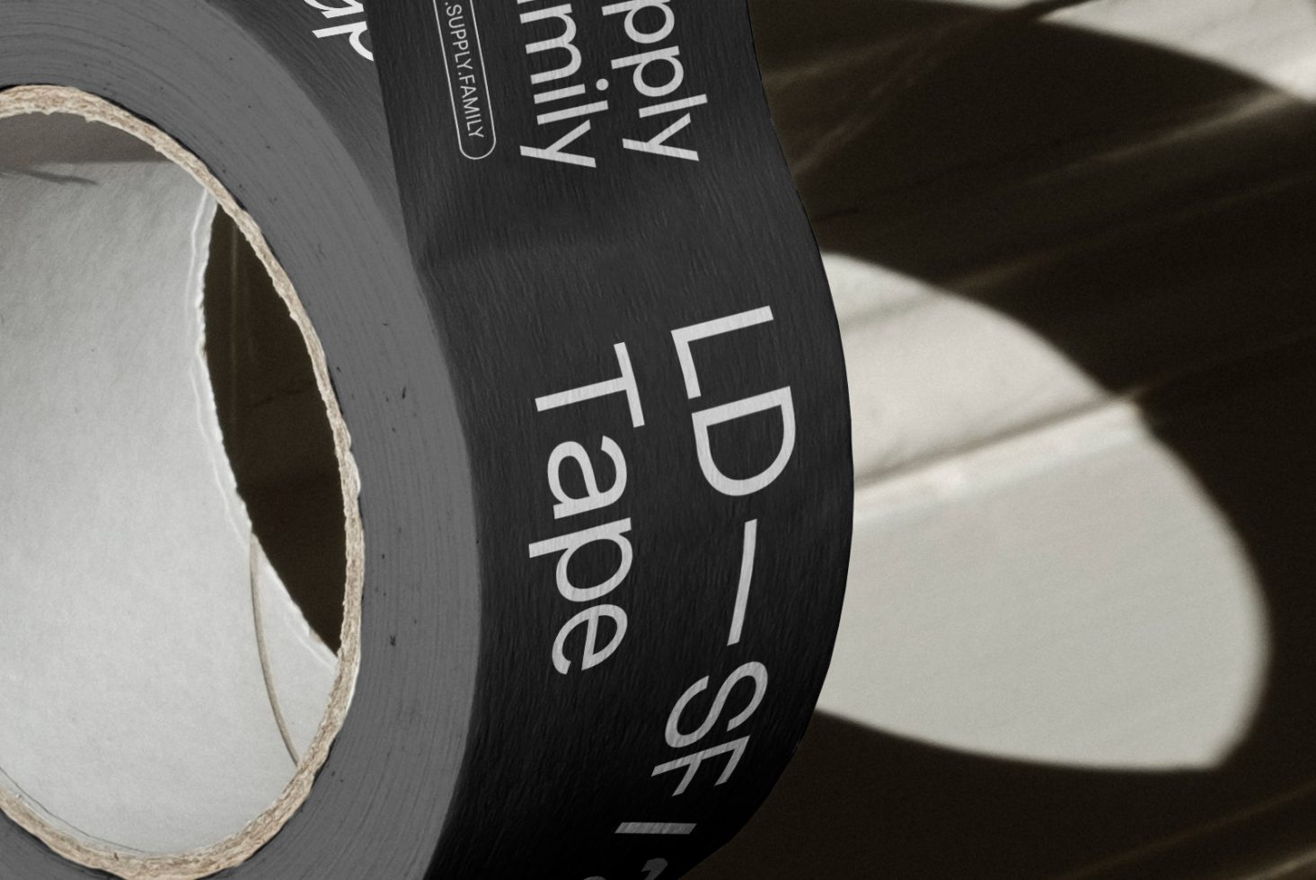 Close-up of a roll of black adhesive tape with white text, ideal for mockup graphics or texture overlay for designers.