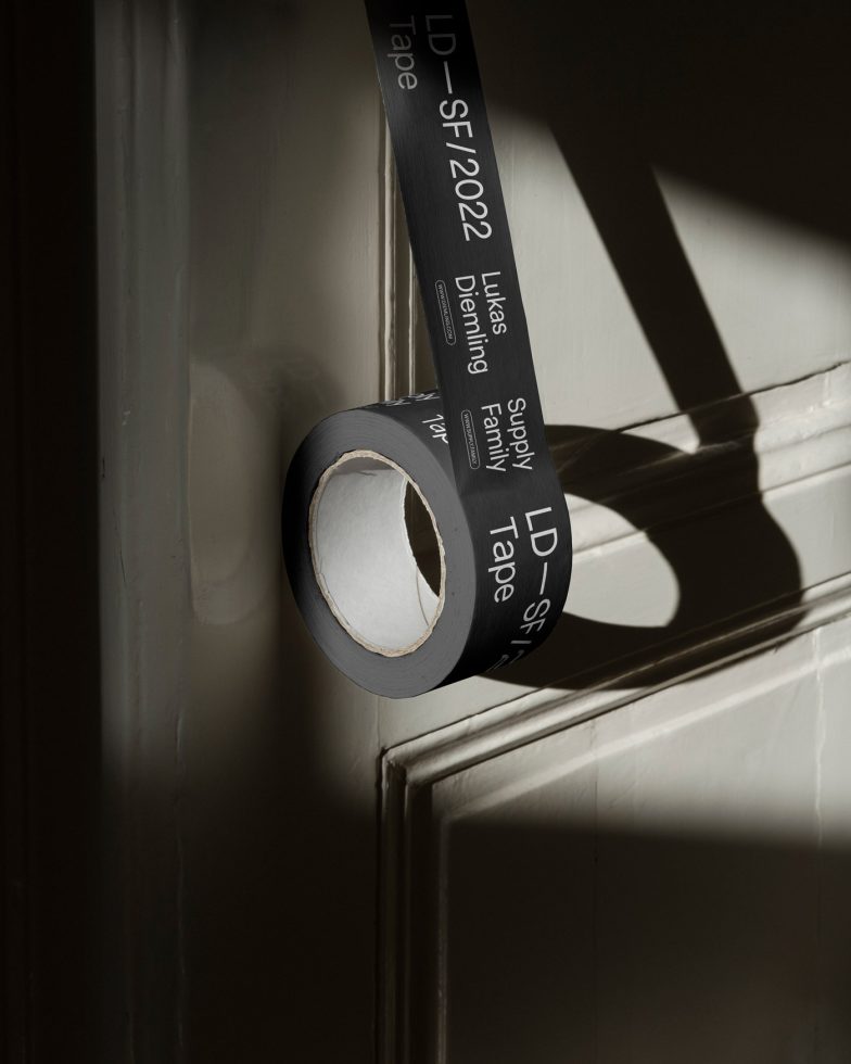 Roll of adhesive tape with text and shadow play on beige wall, graphic design element, mockup resource.