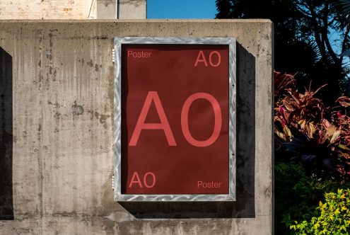 Outdoor poster mockup on concrete wall with metallic frame for design presentations, suitable for displaying graphic designs, posters, and adverts.