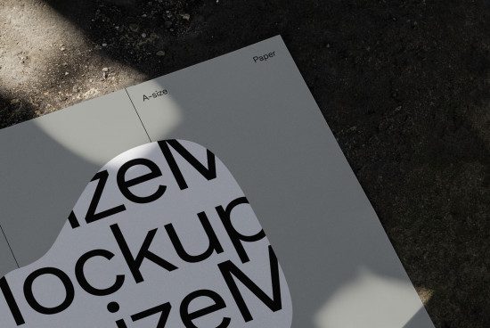 A-size paper mockup with realistic shadow overlay for showcasing font and graphic design on a textured ground surface.