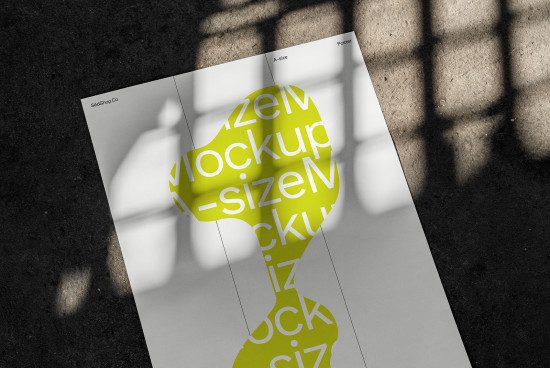 Two A-size poster mockups with bold yellow typography shadows on textured floor, showcasing design layout presentation.