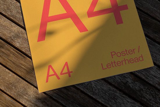 Realistic A4 paper mockup on wooden background with distinct shadows for showcasing poster or letterhead designs.