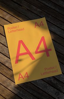 Yellow A4 poster mockup with bold red letters on wooden floor