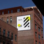 Urban billboard mockup on brick building exterior for outdoor advertising design display, clear blue sky, template.