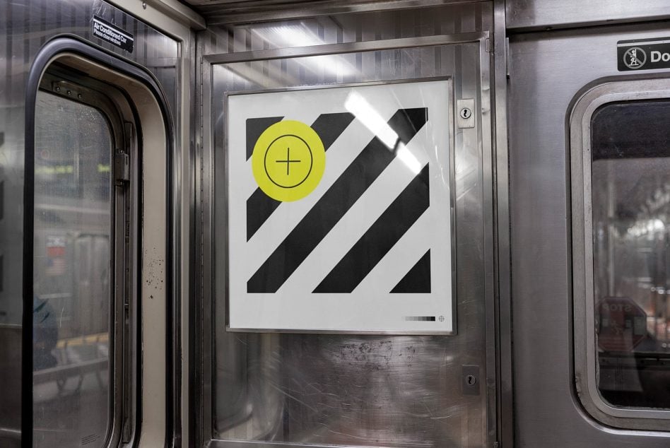 Subway car interior ad with black diagonal stripes, bright yellow circle symbol on white background