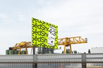 Bright yellow billboard mockup mounted on yellow industrial crane over water