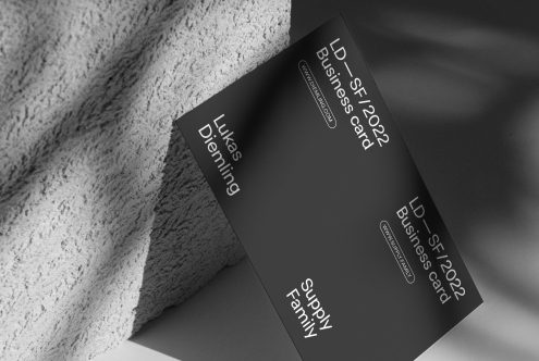 Black business card mockup with elegant typography on textured background, showcasing design and print quality for designers.