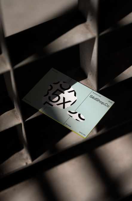 Light blue business card mockup shot overhead with shadow overlay