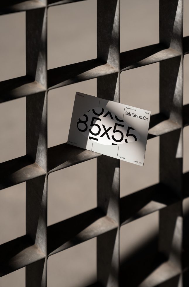 Mockup of a business card held against a geometric metal grid background showcasing a stylish modern design perfect for designers seeking professional templates.