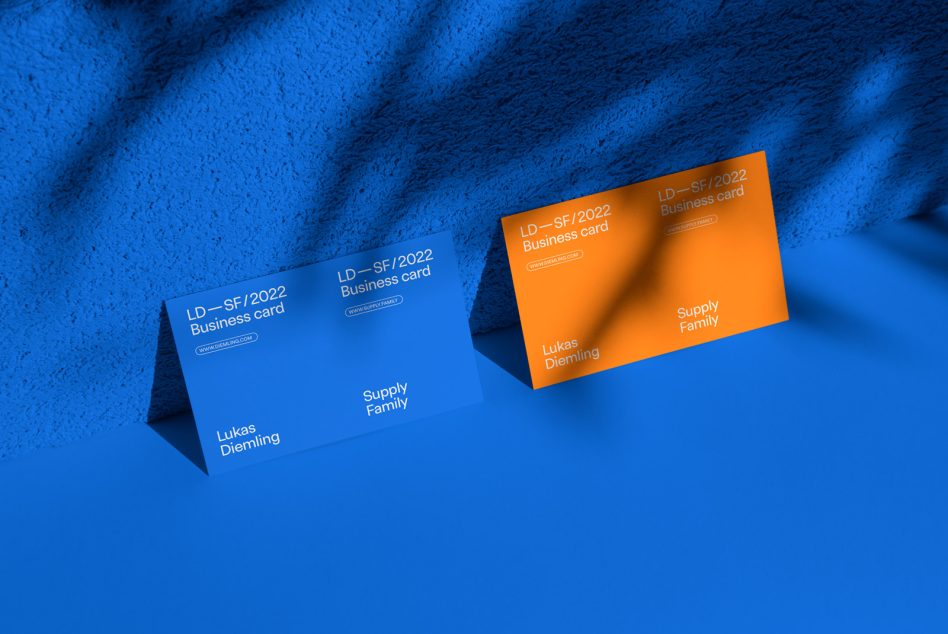 Business card mockup design with blue and orange cards on a textured blue background, perfect for designers and branding presentations.