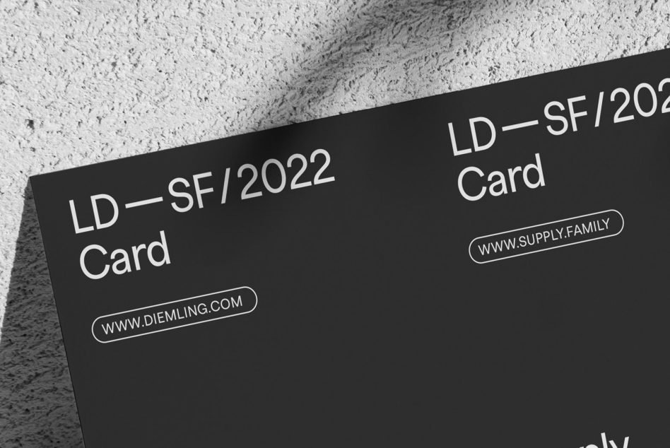 Elegant black business card mockup with minimalist typography design, angled view on textured surface for graphic and template showcase.