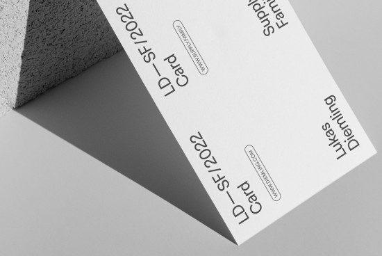 Minimalist business card mockup with textured stone, clean design layout, and shadow overlay, ideal for presentations and portfolios.