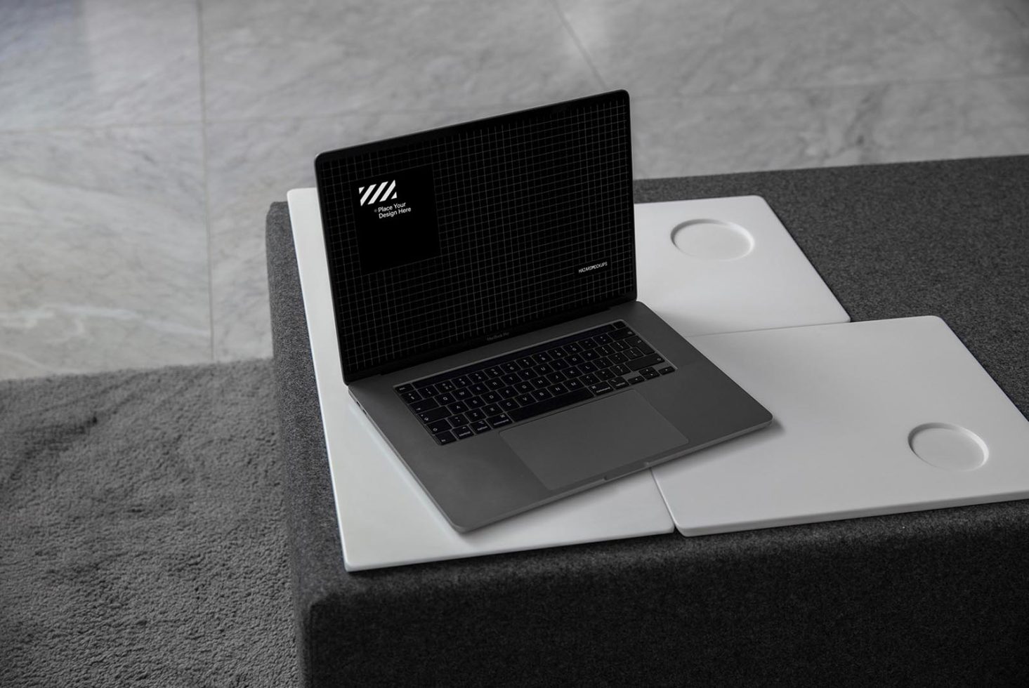 Laptop mockup on textured desk with ceramic tiles, modern device for graphic design showcase, elegant presentation template.