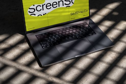 Laptop mockup on concrete with dynamic shadows, showcasing vibrant screen design for digital asset marketplace, ideal for template display.