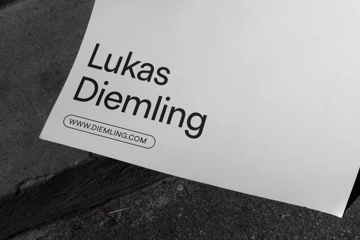 Professional business card mockup lying on textured surface, displaying bold typography, designer portfolio link, angled view for designers.