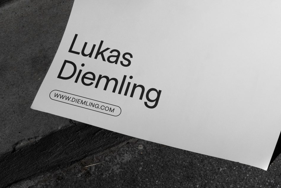 Close up of white poster showing text detail on gray concrete surface