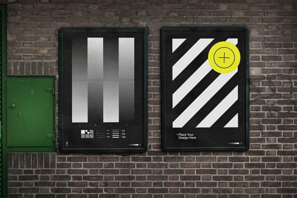 Pair of dark posters on brick wall with diagonal stripes, one showing gradient bars