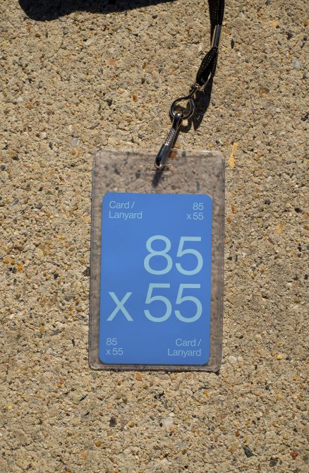 ID card badge mockup 85x55 hanging from black lanyard on ground