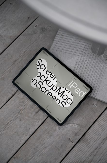 Tablet screen mockup on weathered wood floor showing design template