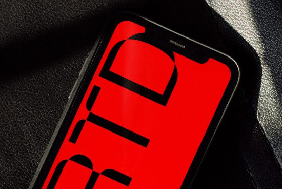 Smartphone mockup with bold red graphic design on screen against black textured background, ideal for presenting digital branding and UI designs.