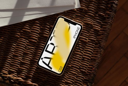 Smartphone mockup on woven texture with sunlight and shadows, ideal for presenting app designs or mobile interfaces to clients.