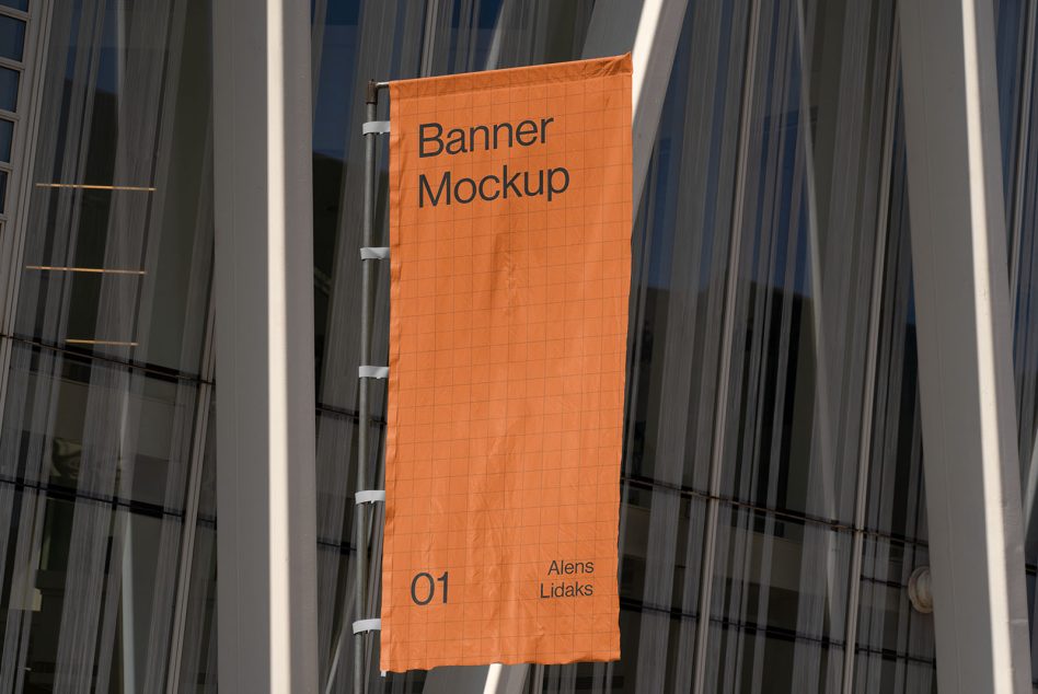 Vertical orange banner suspended between metal columns on modern building facade