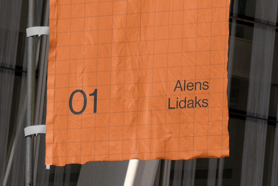 Orange hanging banner with grid texture on metal railing with dark metal backdrop
